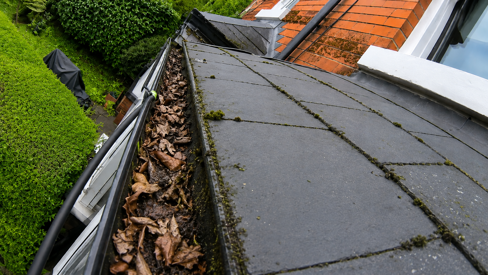 Pre-clean gutter survey showing heavy sludge and blockages